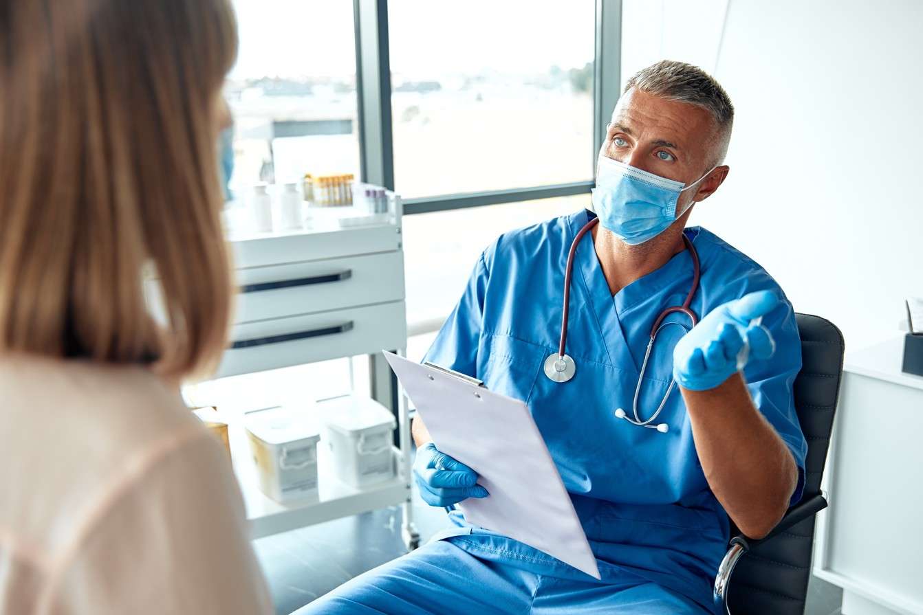 Médico en consulta con paciente explicando resultados, ejemplo de atención centrada en la gerencia en calidad de la salud.