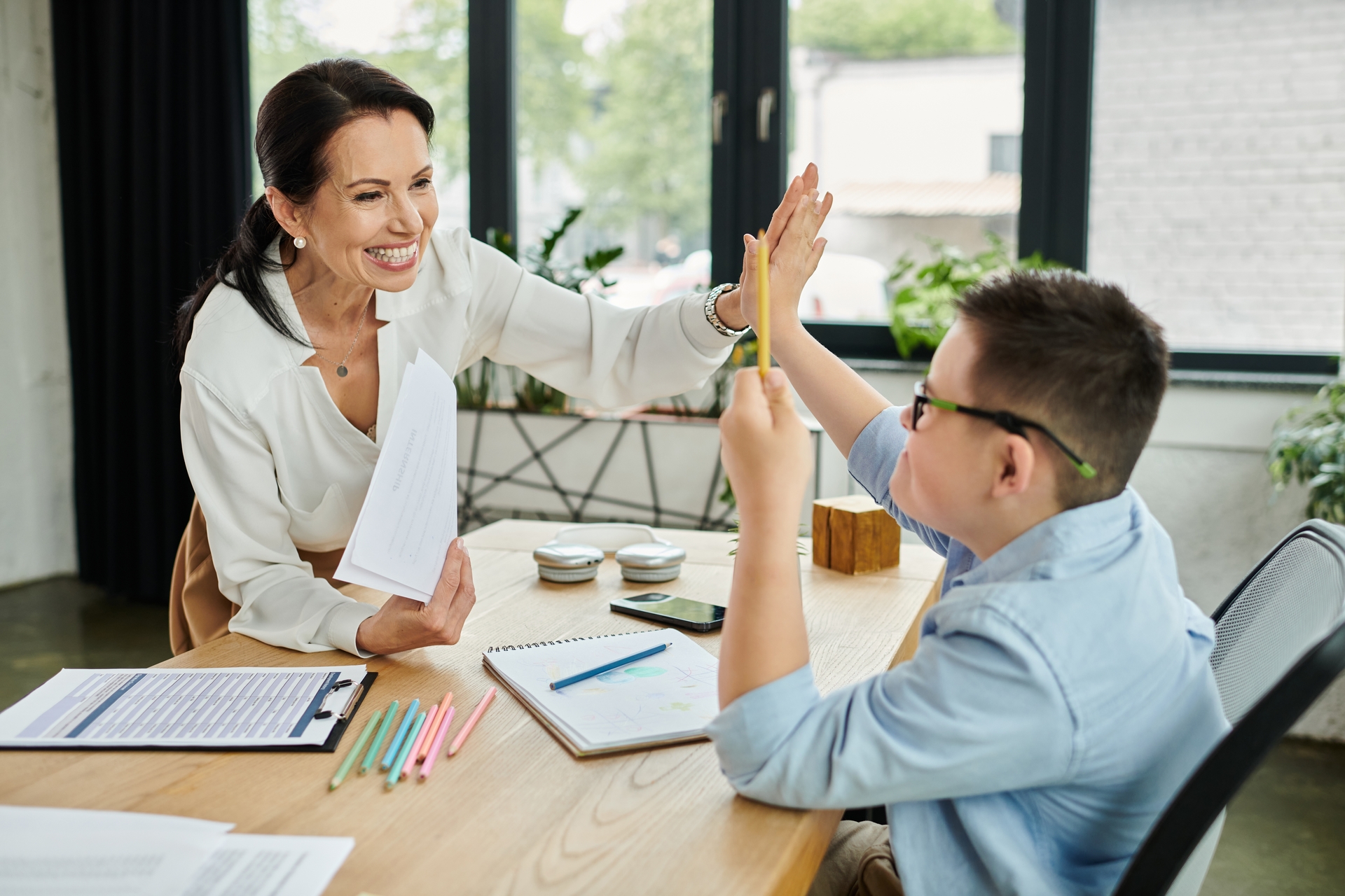 Docente aplicando estrategias pedagógicas de inclusión con un niño, fomentando el desarrollo infantil y la transición de la educación especial a la inclusiva."