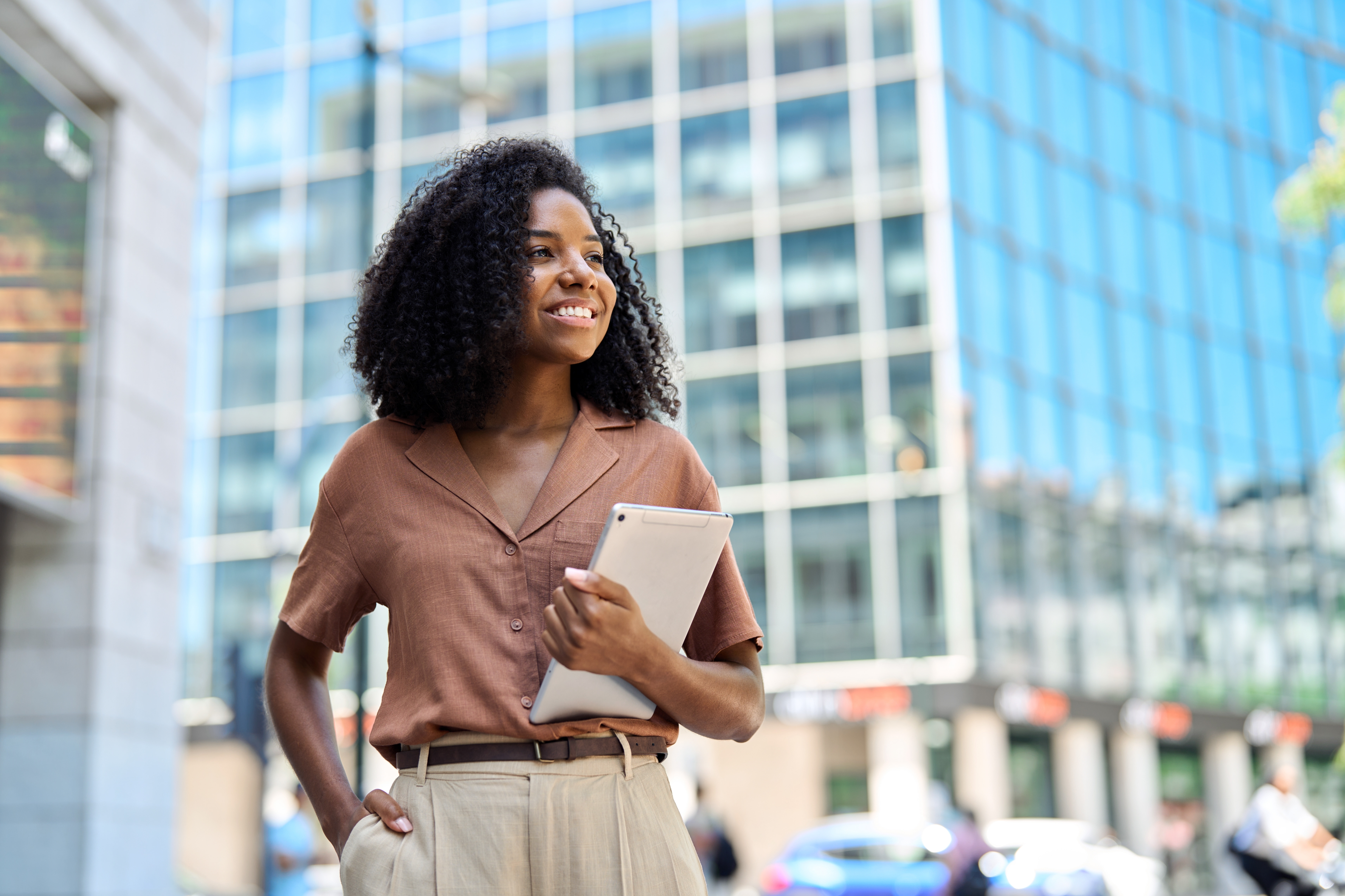 Mujer con tablet en ambiente urbano y elementos de innovación digital, simbolizando el crecimiento profesional que ofrece el MBA Presencial Ibero.