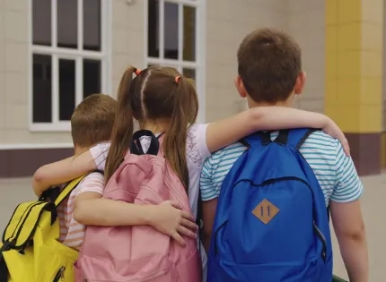 Niños caminando juntos hacia el colegio, símbolo del acompañamiento y las estrategias para el desarrollo integral en la infancia.